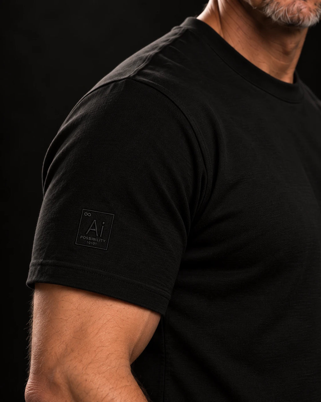 Close-up of the tone-on-tone embroidered Ai + You element tile on the right sleeve of the Possibility Fitted Tee